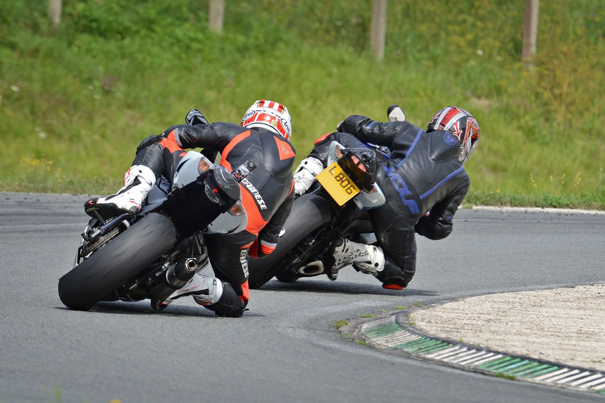 Track day riders rear view going around a corner