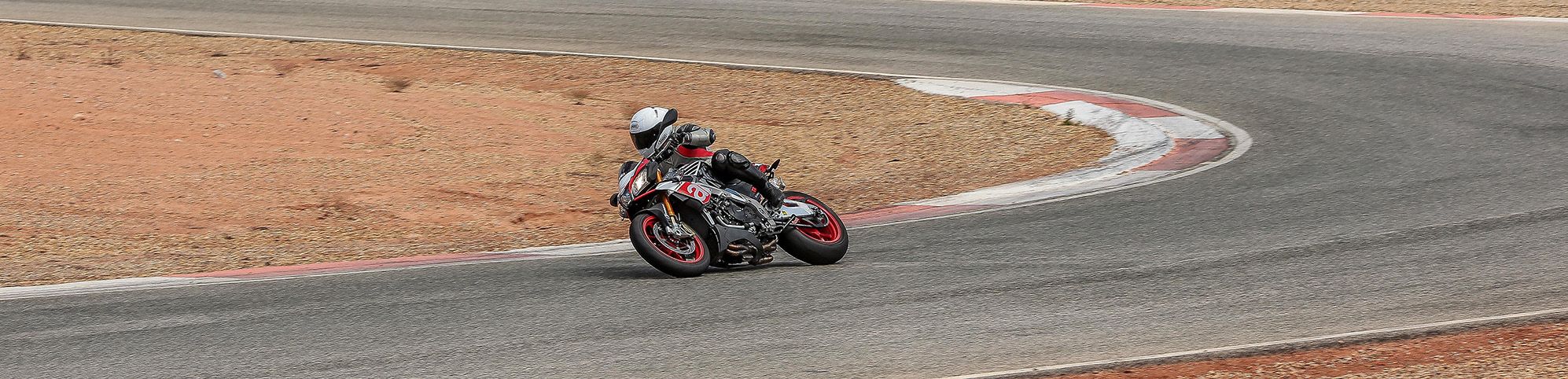 Aprilia TUONO cornering with knee down on a track day