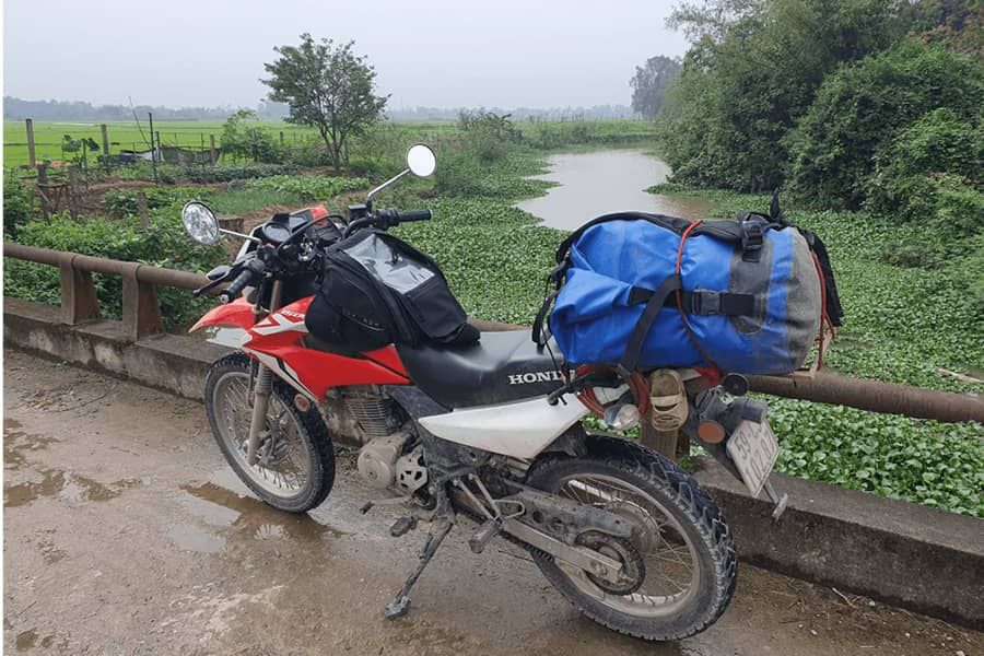 Red Honda Motorbike in Vietnam parked on a small bridge