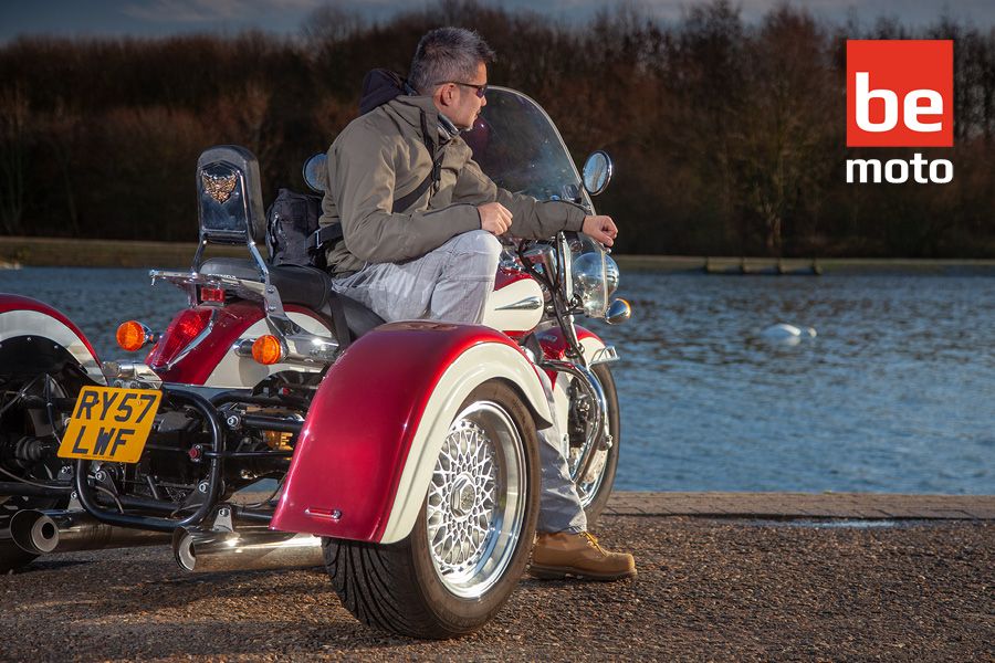 Trike parked up with rider sat by water front