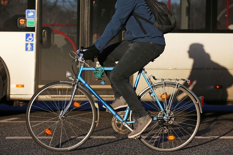 A cyclist riding near a bus