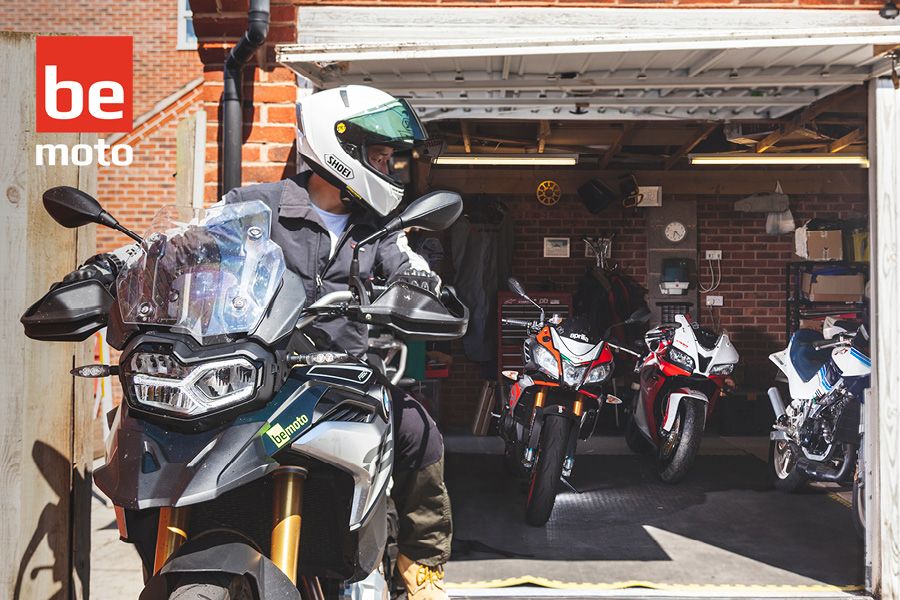 Biker on his motorcycle looking back to his multibike garage