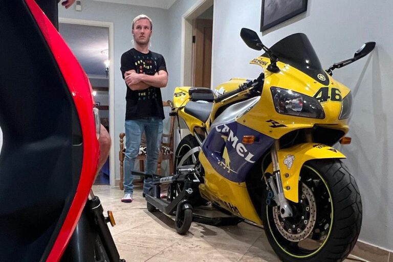 Davey Todd standing indoors next to a Yamaha R1 in Camel replica livery with number 46, styled after Valentino Rossi’s MotoGP bike.