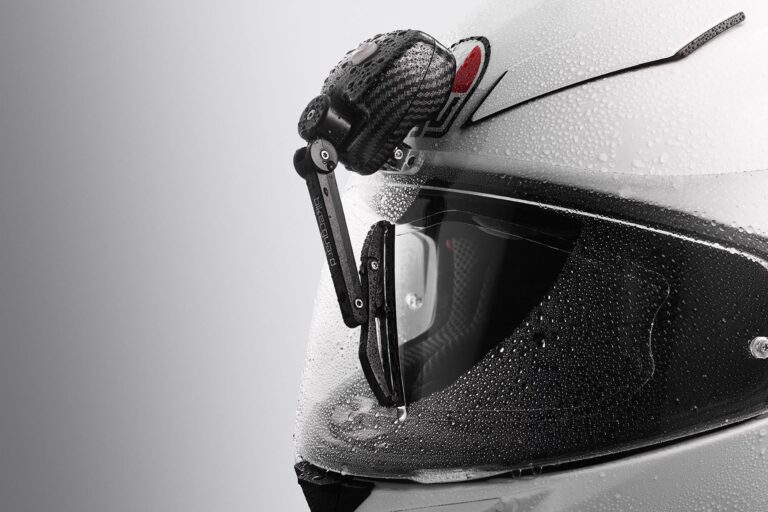 Close-up of BikerGuard visor wiper kit on motorcycle helmet, showing rain droplets wiped from visor for clear visibility in wet riding conditions.
