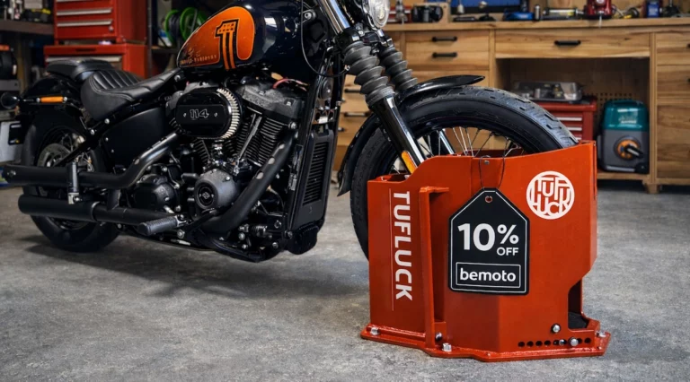 Harley-Davidson motorcycle secured in a workshop garage using a red TufLuck Tough Motorcycle Parking Lock with a 10 percent off BeMoto discount tag attached.