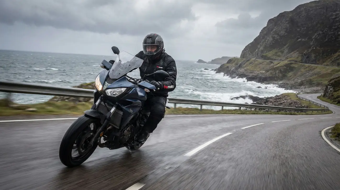 A motorcyclist demonstrating smooth cornering on a wet road.